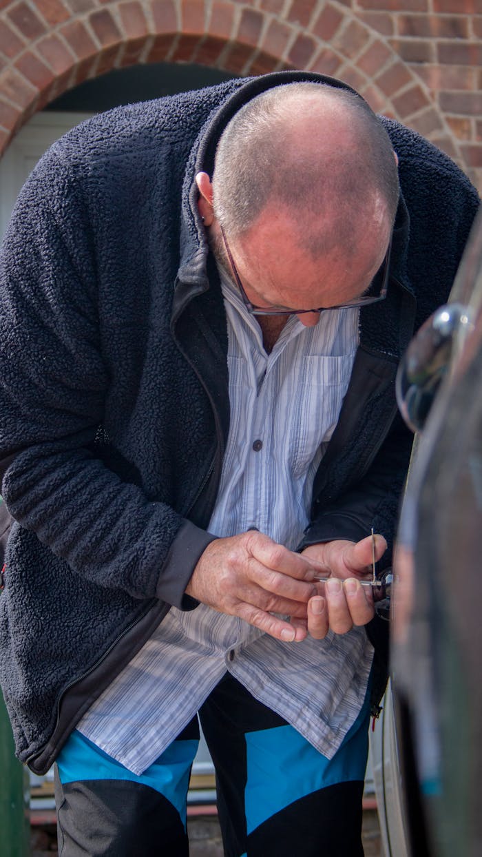 creative-02 A locksmith works on unlocking a car, demonstrating his expertise and tools.